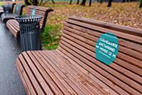 A sign in Russian on a park bench about 'Keeping a