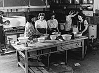 Teaching young women cooking in a kitchen
1950s
