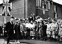 Walking with Lord Rosebery, the Queen, in navy and
