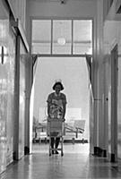 A young nurse pushing a trolley down a hospital co