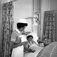 A nurse taking the pulse of her young patient on t