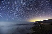 Star trails, fog and car lights at night along the