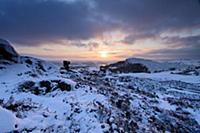 View of snow covered gritstone escarpment at sunse