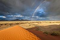 Storm with rainbows over sand dunes, Namibia