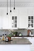 Pendant lamps above island counter in white countr