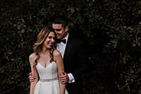 Happy young bride and groom laughing in front of f