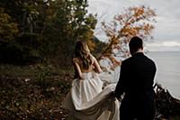 Romantic young groom carrying bride's wedding dres