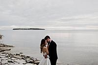 Romantic young bride and groom hugging on lakeside