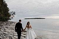 Romantic young bride and groom strolling along lak
