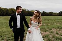Romantic young bride and groom holding hands and l