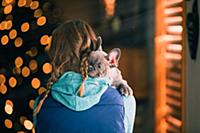 Girl carrying puppy indoors