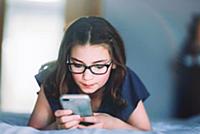 Girl using smartphone on bed