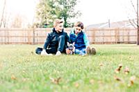 Children playing with puppy on grass