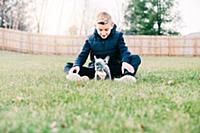 Boy playing with puppy on grass