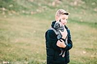 Boy carrying puppy outdoors