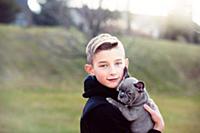 Boy carrying puppy outdoors