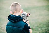 Boy carrying puppy outdoors