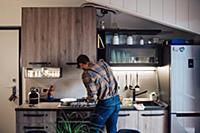 Mid adult man preparing food at kitchen hob, rear 