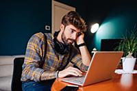 Mid adult man sitting at living room table looking
