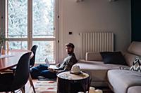 Mid adult man sitting on living room floor using l