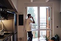 Mid adult man holding drinking coffee and looking 