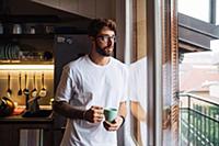 Mid adult man with coffee cup gazing out through a