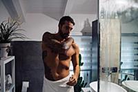 Mid adult man with tattoos getting ready in bathro