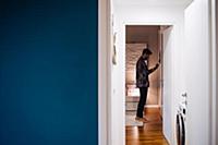 Mid adult man getting dressed in bedroom, view fro