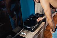 Mid adult man playing vinyl record on turntable, c