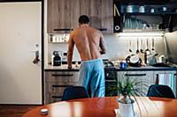 Mid adult man preparing breakfast at kitchen hob, 