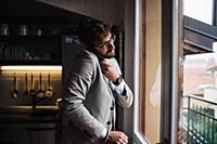 Mid adult man making smartphone call while getting