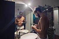 Mid adult man with tattoos using smartphone touchs
