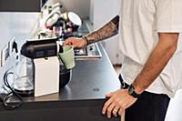 Mid adult man pouring coffee from coffee machine o