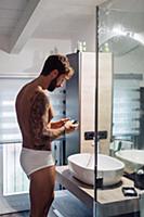 Mid adult man with tattoos looking at smartphone a