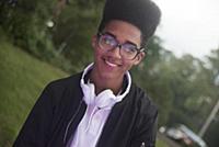 Teenage boy with afro flat top hairstyle in park ,