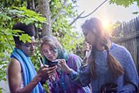 Three male and female teenagers in garden looking 