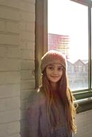 Teenage girl with long brown hair and knit hat by 