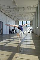 Teenage girl doing handstand and splits in dance s