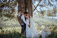 Romantic couple on wedding day kissing in woodland