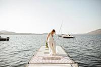 Young bride in wedding dress strolling on windy la