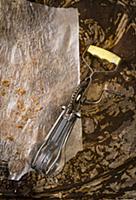An old hand whisk on baking paper