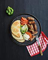 Grilled cevapcici with balkan flatbread, fresh veg