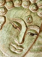 Buddha's face close up. Wooden relief.