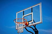Basketball hoop and backboard with blue sky.