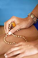 Female hand with rosary, closeup.