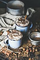 Hot chocolate in blue mugs with whipped cream and 