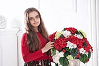 Девочка позирует в студии с букетом цветов